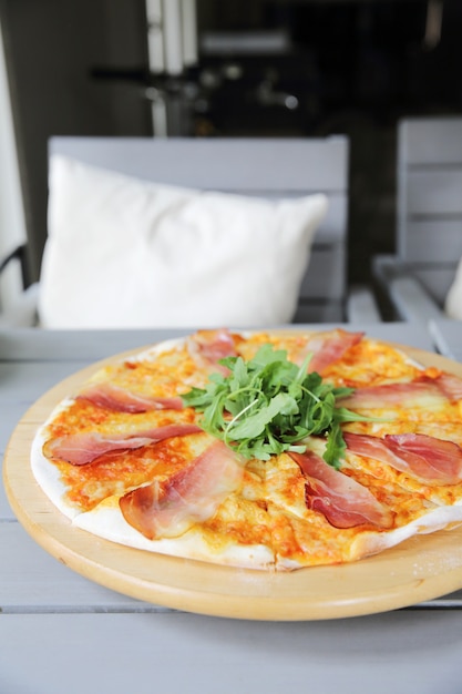 Pizza margherita con jamón de parma y rúcula