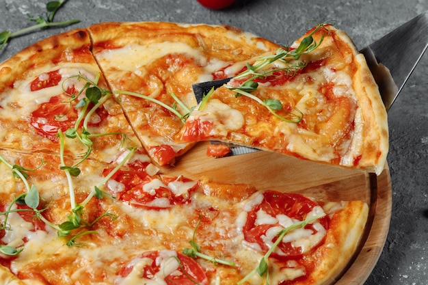 Pizza Margherita no fundo de pedra preto, vista superior. Pizza Margarita com tomate, manjericão e queijo mussarela close-up