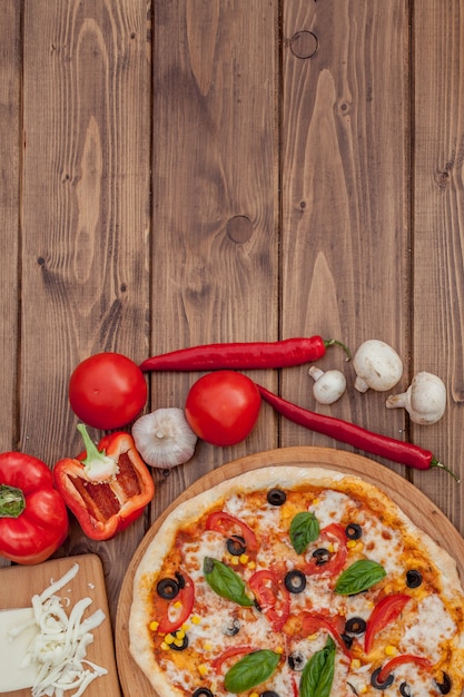 Pizza Margherita oder Margarita mit Mozzarella, Tomaten, Oliven. Italienische Pizza auf hölzernem Hintergrund