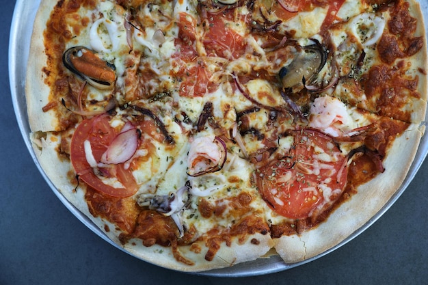 Foto pizza de marisco, con camarones de calamar de mejillón y tomate, comida italiana en la vista superior