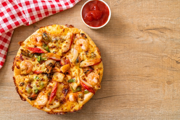 Pizza de mariscos (camarones, pulpo, mejillón y cangrejo) en bandeja de madera