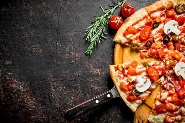 Foto pizza mexicana aromática en rodajas en una tabla para cortar