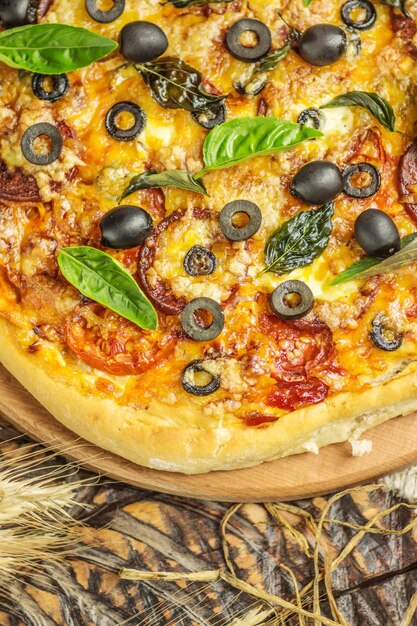 Pizza mista com frango pimenta azeitonas cebola manjericão na tábua de pizza