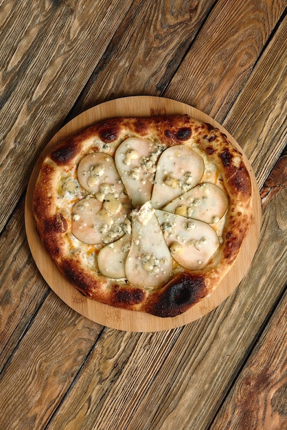 Pizza mit Birnen und Gorgonzola-Käse italienische Pizza mit Birne und Blauschimmelkäse auf Holzhintergrund