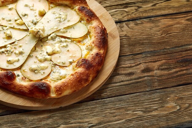 Pizza mit Birnen und Gorgonzola-Käse italienische Pizza mit Birne und Blauschimmelkäse auf Holzhintergrund