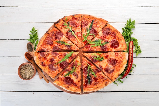 Pizza mit Chili und Salami Draufsicht auf Holzhintergrund Kopierbereich