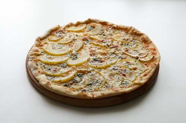 Pizza mit Käse und Birnenfrucht auf Holzbrett