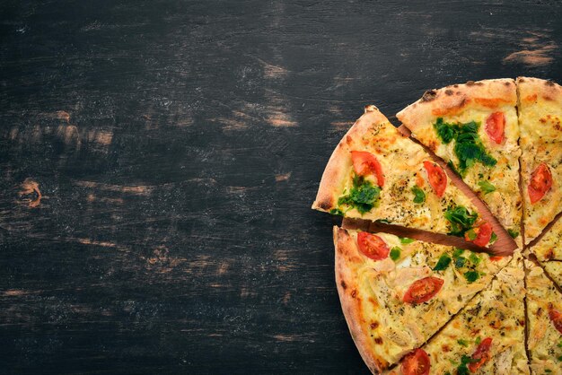 Foto pizza mit kirschtomaten suluguni-käse und basilikum italienische küche auf holzhintergrund freier platz für text ansicht von oben