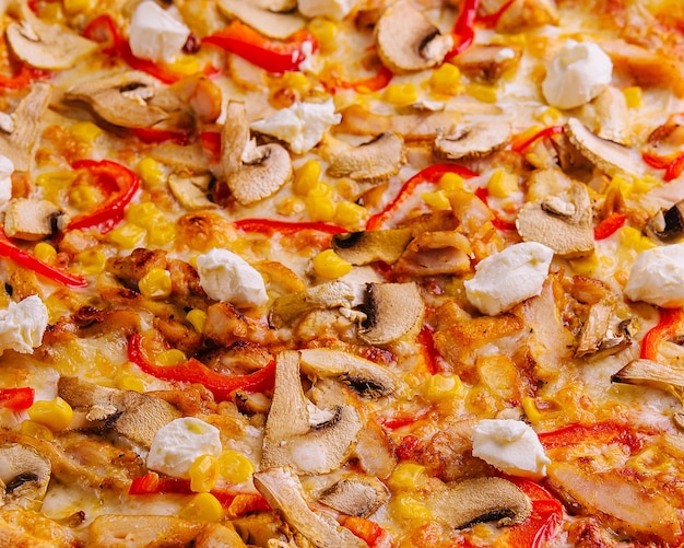 Pizza mit Paprika, Maisfleisch und Pilzen in der Nähe