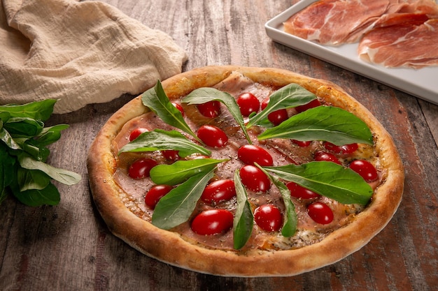 Pizza mit Parmaschinken, Rucola und Kirschtomaten