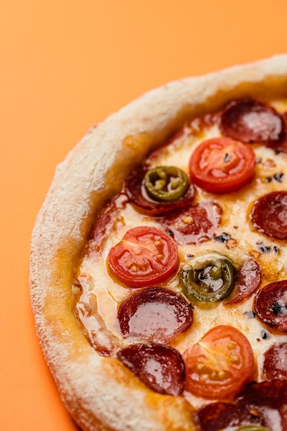 Pizza mit Räucherwurst-Kirschtomaten, getrockneten Chilischoten, Jalapenopfeffer und Mozzarella Nahaufnahme Kopierbereich