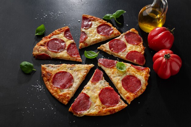 Pizza mit Salami und Käse auf dunkler Oberfläche