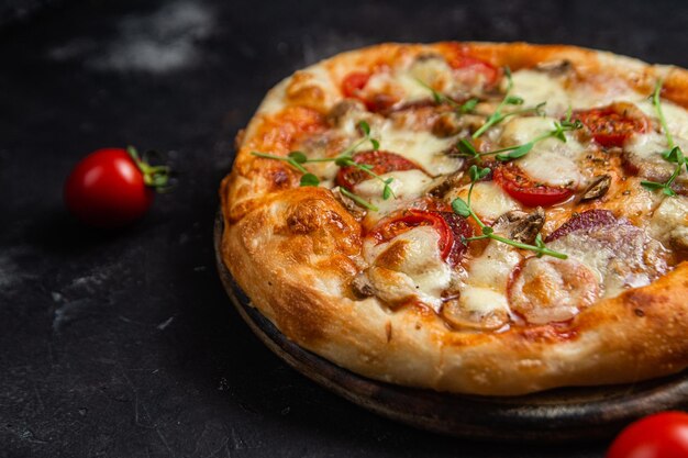 Pizza mit Salami und Pilzen auf dunklem Hintergrund