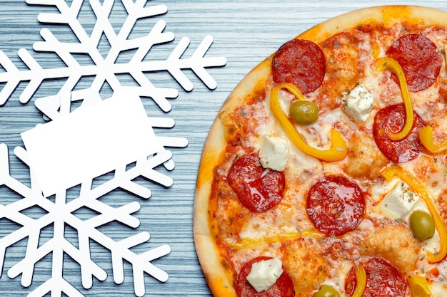 Pizza mit Schneeflockendekoration. Winterpizza