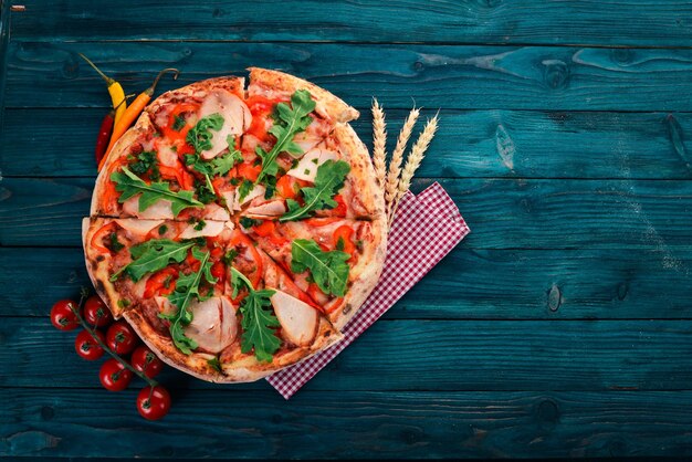 Pizza mit Speck, Paprika und Rucola italienische Küche auf Holzhintergrund Freier Platz für Text Ansicht von oben