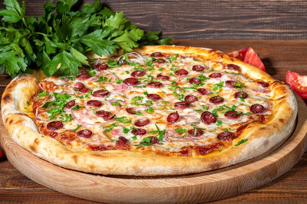 Pizza mit Speck und Käsekräutern und Kirschtomaten Mit Mozzarella-Garnelen und Tintenfischmuscheln und anderen Produkten auf Holzhintergrund