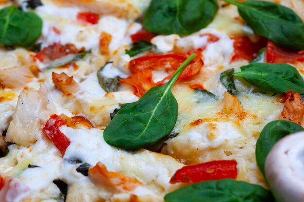 Foto pizza mit spinat, kirschtomaten und gorgonzola-käse auf einem hellen hintergrund