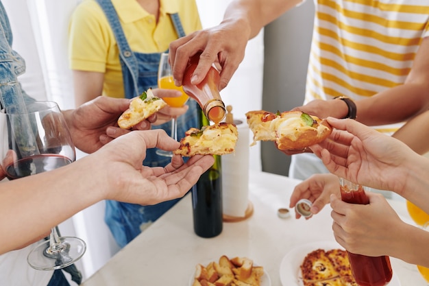 Pizza mit würziger Sauce belegen