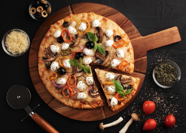 Pizza con mozzarella, aceitunas y champiñones. Cocina italiana. Ingredientes para hacer pizza