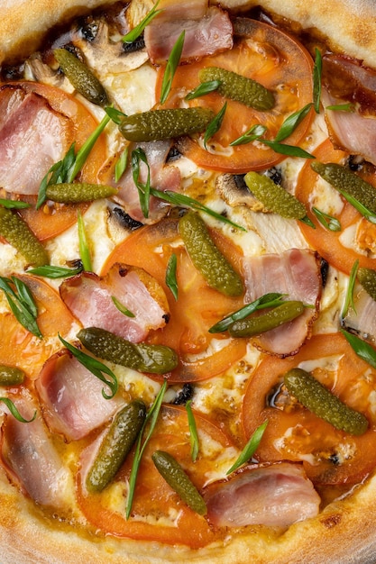 Una pizza con muchos ingredientes que incluyen cebollas verdes, tocino y queso.