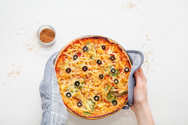 Pizza na mão decorada com azeitonas e especiarias