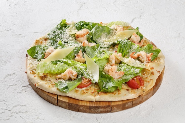 Pizza Napoli en placa de madera aislada sobre fondo de hormigón blanco
