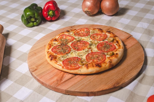 Pizza napolitana encima de una mesa con un mantel a cuadros