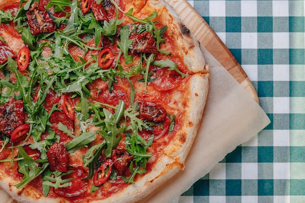 Pizza napolitana picante con jamón, queso, rúcula, albahaca, tomates, pimienta de pepperoni rociada con queso