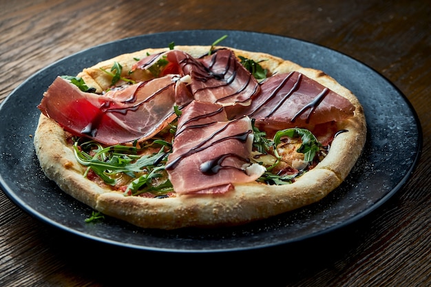 Pizza no forno a lenha com jamon, rúcula, molho vermelho e vinagre balsâmico. pizzette uma espécie de pizza italiana