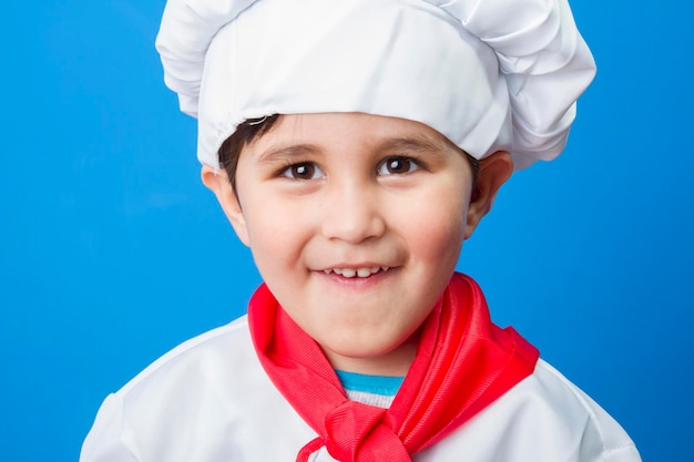 Pizza, o menino de terno do cozinheiro. adorável garotinho com chapéu de chef e avental sorrindo para a câmera na cozinha. menino com chapéu de chef