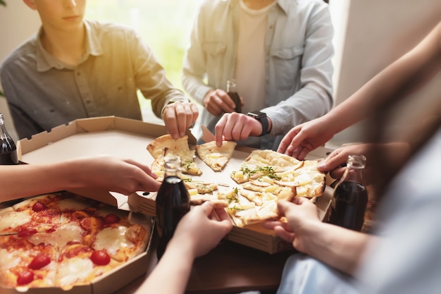 Pizza-Party-Gruppe von Freunden, die sich unterhalten, Pizza essen, süßes Sodawasser trinken?