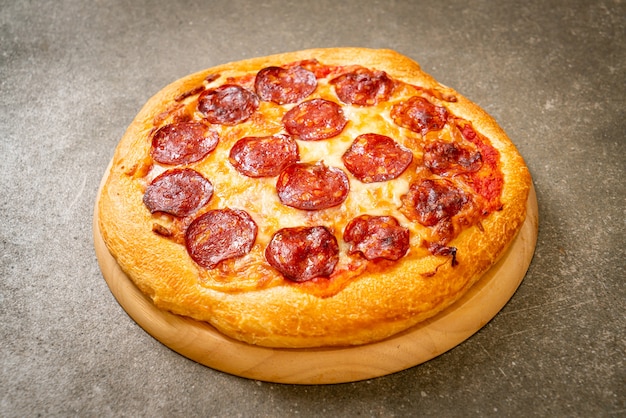 Pizza de pepperoni en bandeja de madera - estilo de comida italiana