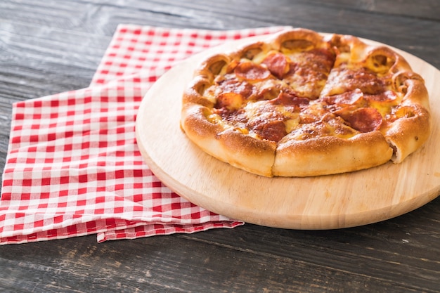 Pizza de Pepperoni casera en plato de madera