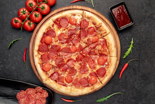 Pizza de pepperoni con ingredientes sobre fondo de piedra