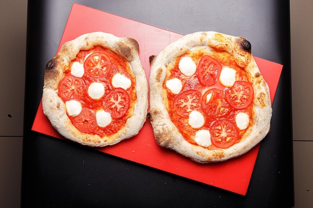 pizza de pepperoni italiana casera, salami y queso, en la tabla de cortar de la cocina, espalda negra aislada