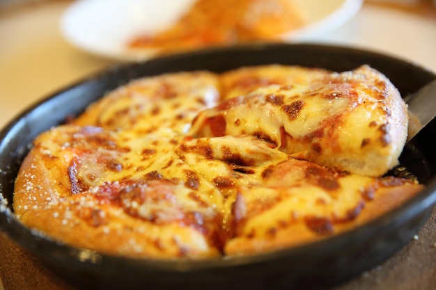 Pizza de pepperoni, pizza con queso mozzarella de pepperoni y tomates con salsa de comida italiana de fondo