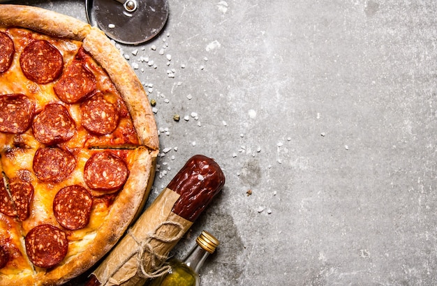 Pizza de pepperoni con salami y queso. Sobre mesa de piedra.