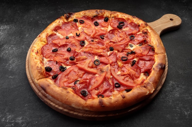 Pizza de pepperoni en una tabla de madera redonda