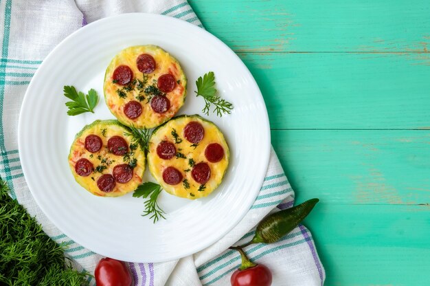 Pizza pequena de abobrinha nos círculos com calabresa e mussarela