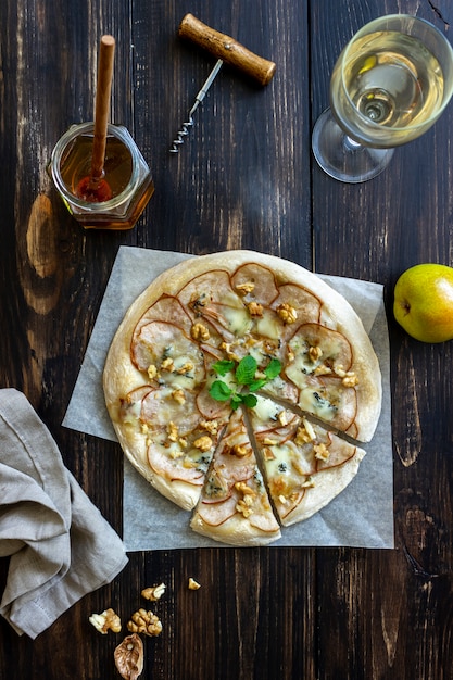Pizza con pera, queso gorgonzola, nueces, miel y menta. Alimentación saludable. Comida vegetariana. Receta.