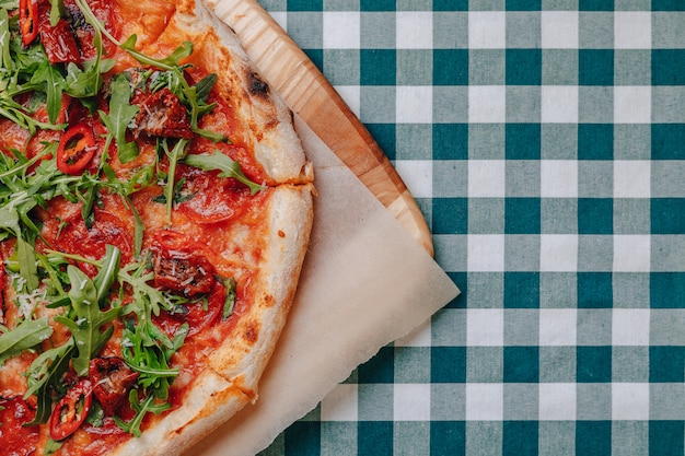 Pizza picante napolitana com presunto, queijo, rúcula, manjericão, tomate, pimenta calabresa pulverizada com queijo