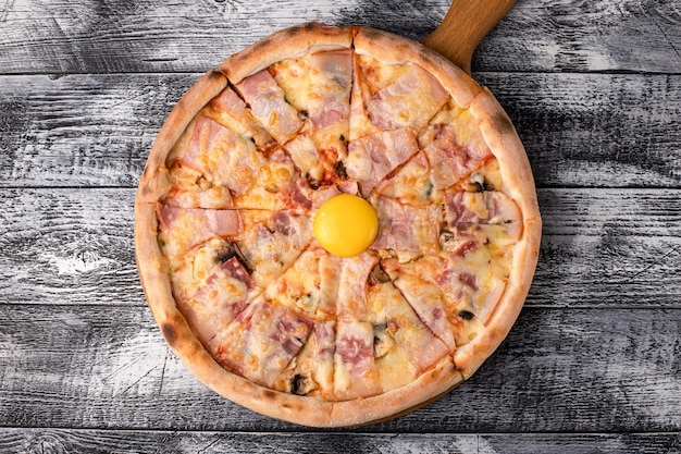 Pizza pizza caliente en un lado de fondo de madera blanca y vista superior