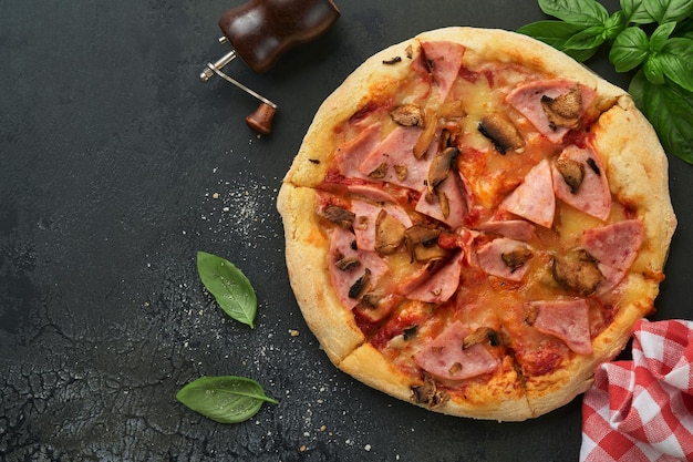 Pizza Pizza tradicional de tocino con champiñones, pepino encurtido y queso e ingredientes para cocinar tomates albahaca sobre fondos de mesa de madera Comida tradicional italiana Vista superior Mock up