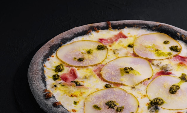 pizza preta com queijo de pêra e presunto