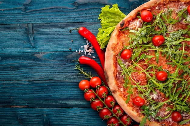 Pizza Primavera Kirschtomaten-Rucola-Käse Auf einem hölzernen Hintergrund Ansicht von oben