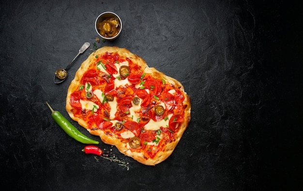 Pizza quadrada de calabresa caseira ou pinza com queijo mussarela derretido, cebolinha verde fresca e pimenta malagueta, vista de cima, disposição plana, cópia espaço