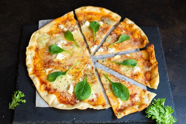 pizza quatro formaggi con variedad de quesos y albahaca