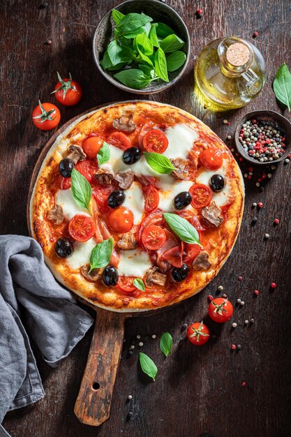 Pizza quente Capricciosa feita de tomate azeitonas queijo e presunto