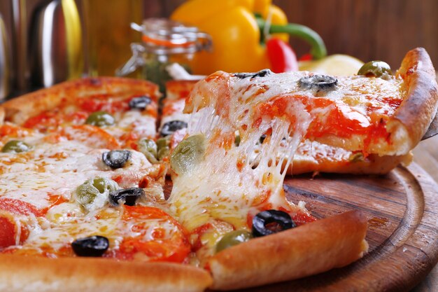 Pizza con queso a bordo y mesa de madera