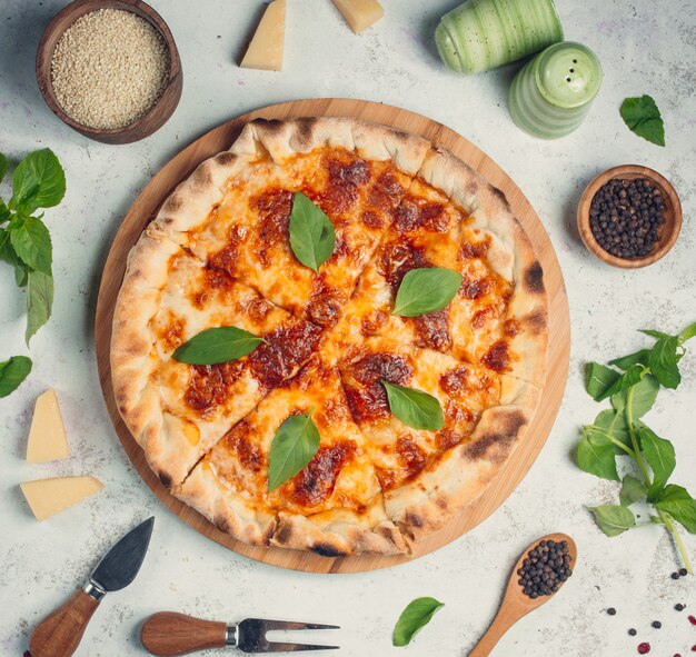 Pizza con queso y hojas de albahaca